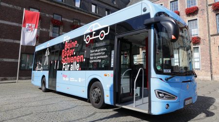 Gebrandeter blauer Bus im "Wege für alle"-Look